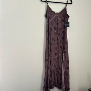 Long spaghetti strap purple dress with slit on lower right leg.